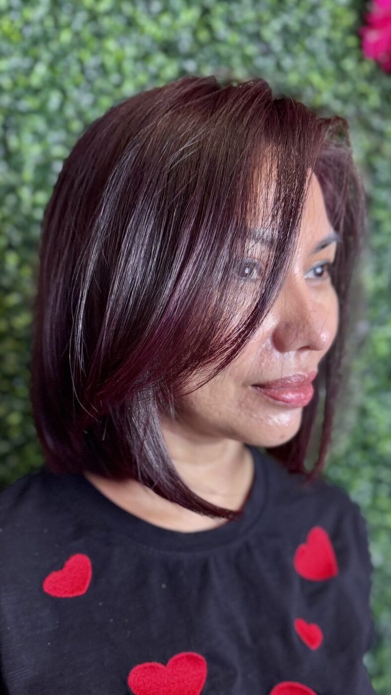 A sleek deep burgundy bob with side-swept bangs