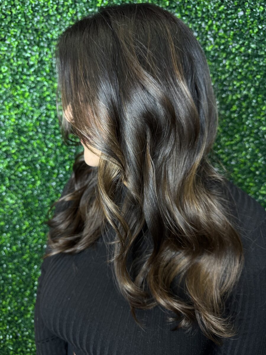 Chocolate brown hair with subtle highlights and glossy waves