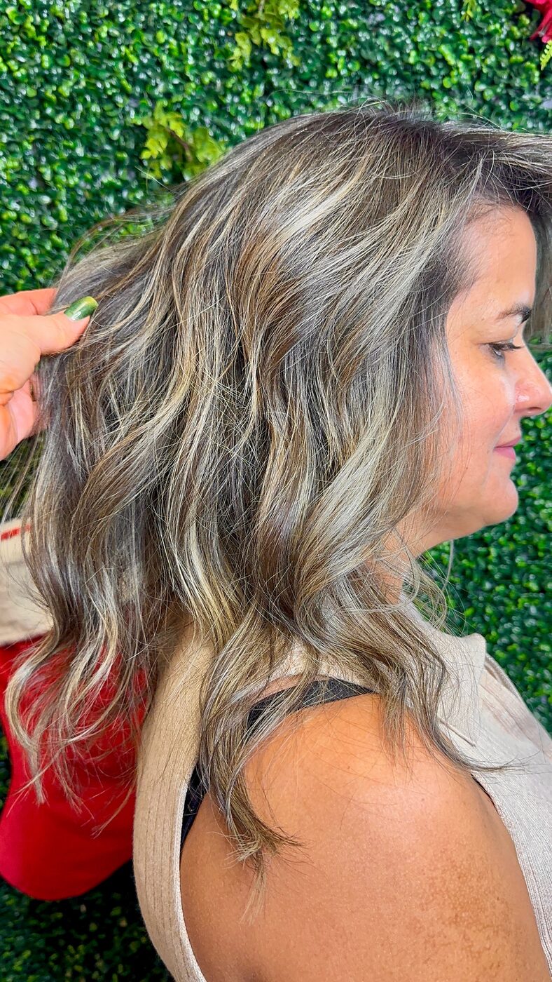 Wavy hair with grey blending highlights, seen from the side