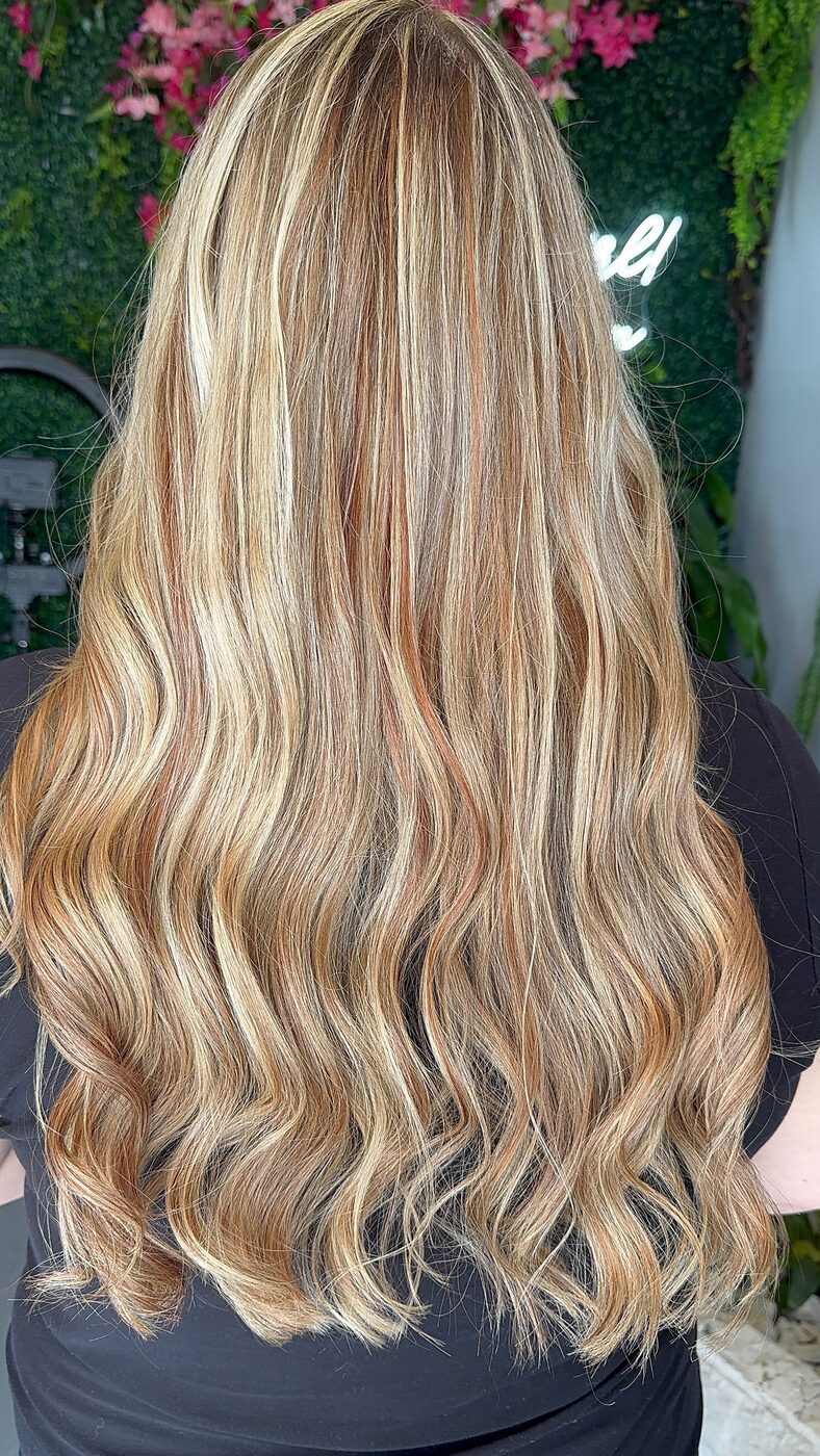 Long honey blonde hair with bright highlights and soft waves, seen from behind
